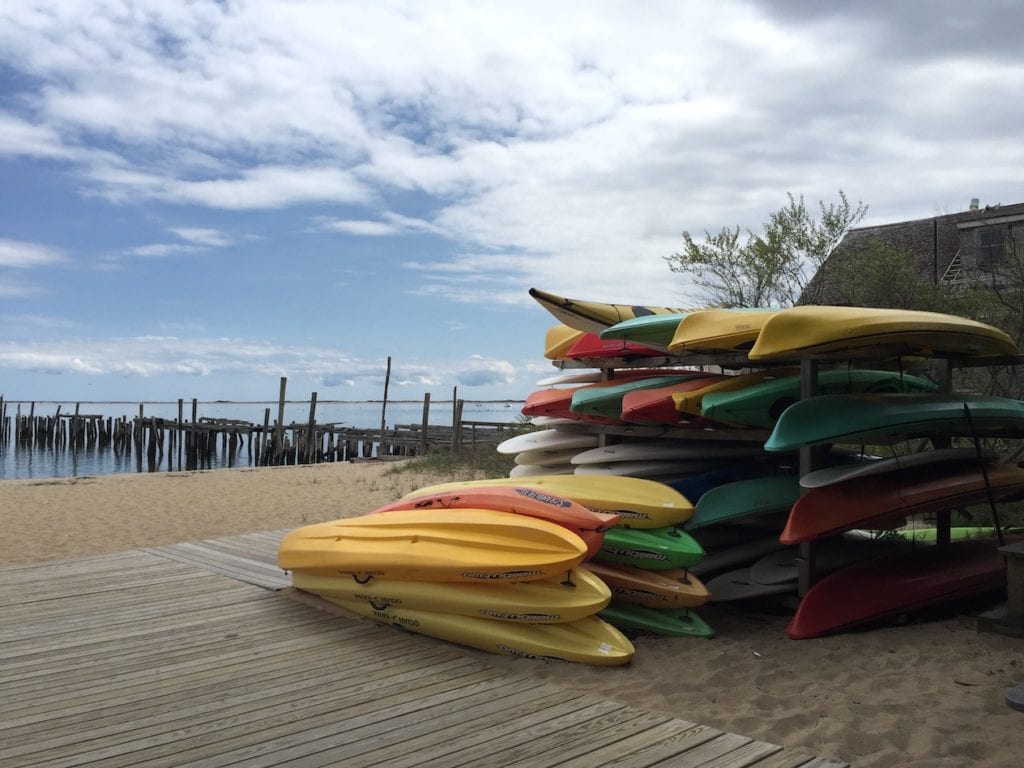 Canoes piled up on a beach.